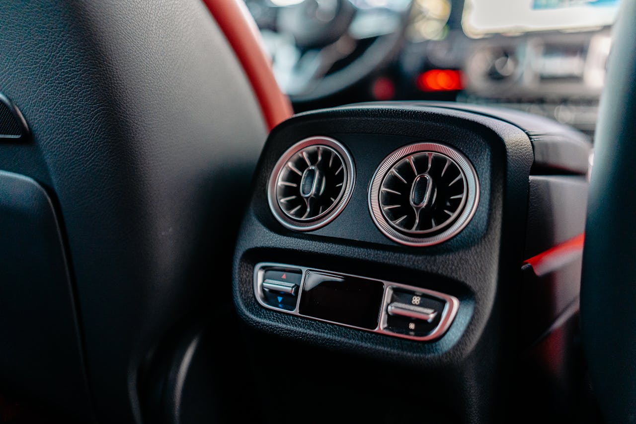 Close-up of a luxury car's air conditioning vents and controls, highlighting interior design.