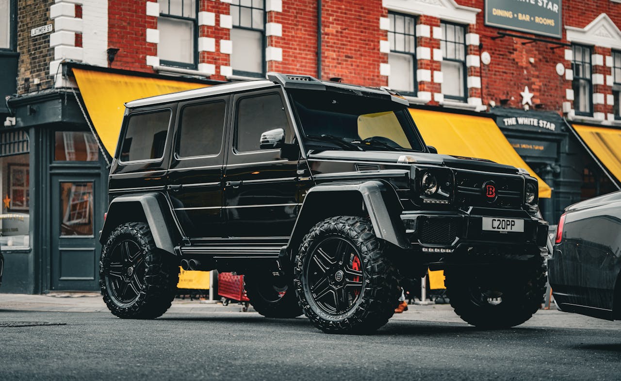 Stunning black Mercedes G-Class SUV parked on city street, showcasing urban style and luxury.