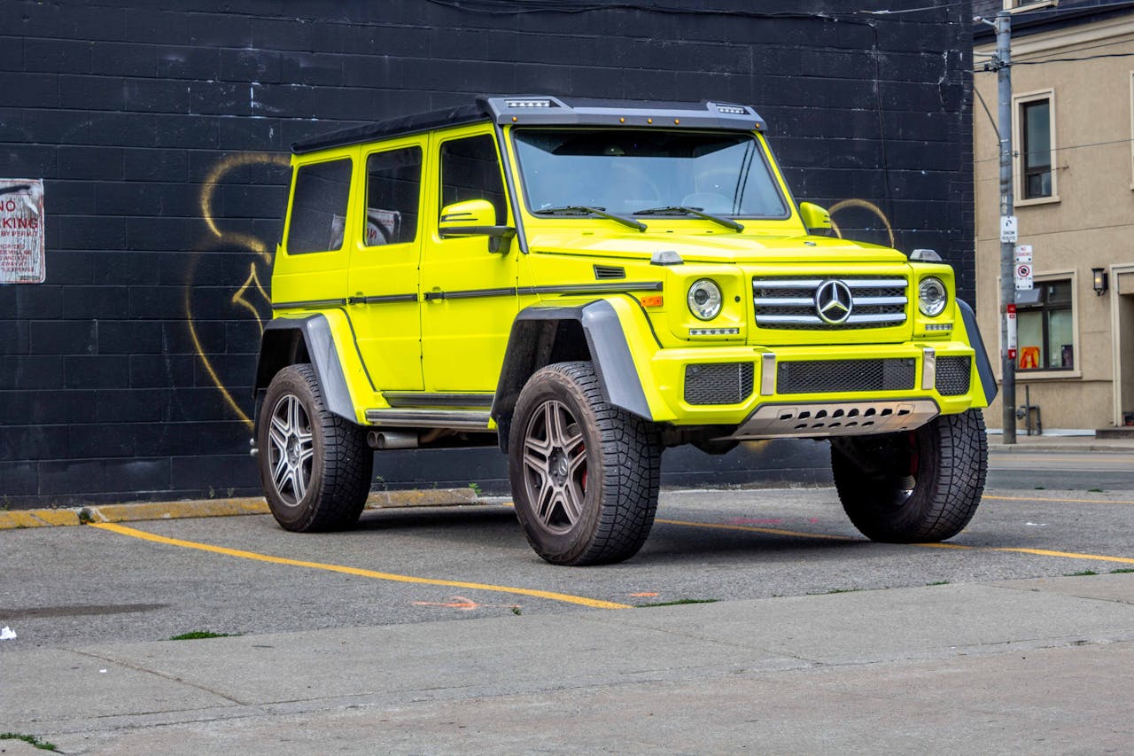 Eye-catching bright yellow SUV parked in a city street with urban backdrop.
